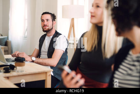 Group of young businesspeople with laptop working in a modern office. Stock Photo