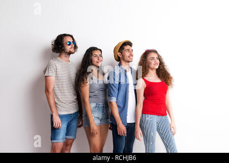 Portrait of joyful young group of friends standing in a studio. Stock Photo