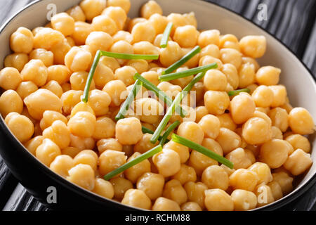 Healthy organic chickpea food with green onions close-up in a bowl on the table. horizontal Stock Photo