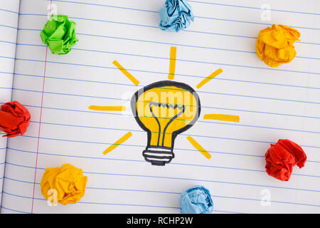 Drawing of a light bulb and colorful crumpled paper balls. New Idea Concept. Close up. Stock Photo