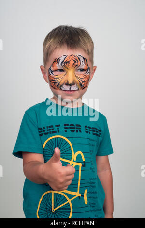 Little charming boy with a tiger face. aqua make-up. face painting Stock Photo