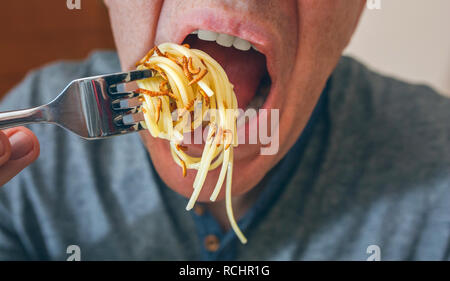 Man eating spaghetti with worms Stock Photo