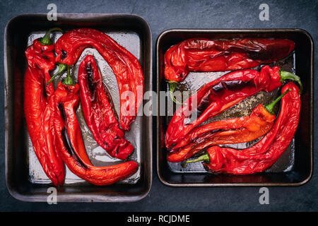 Roasted Organic Ramiro peppers. Cooked red pointed peppers in baking trays Stock Photo