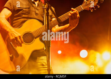 Thessaloniki, Greece - September 22, 2018: acoustic guitar in action on stage performing at a rock concert at the open theater of the city, blur stage Stock Photo