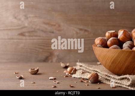 Hazelnuts in wooden bowl on wooden background Stock Photo