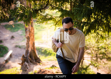 Man using hiking with backpack outdoors in woods Stock Photo