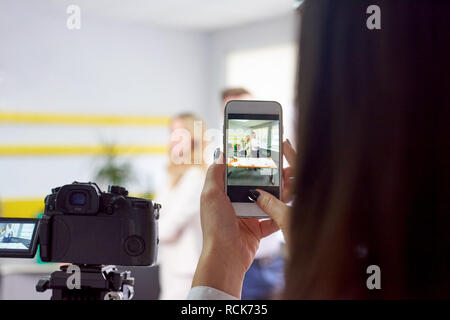 Woman taking photo of business partners actors from backstage. Camera on side Stock Photo