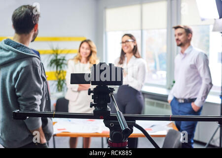 Film director discussing movie plan with the actors in the office scene. Lights pointing to the actors Stock Photo