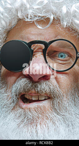 Handsome senior man skeptic and nervous, frowning upset because of problem. Negative person. The emotional face of Santa Clause in glasses. The holiday, expression, emotions, senior, winter, gesture concept. Stock Photo