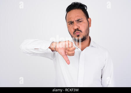 Studio shot of stressed bearded Indian businessman getting bad news Stock Photo