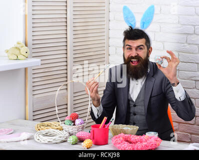 love easter. Bearded man hipster paint easter eggs. Happy easter. Rabbit man with bunny ears. brutal male with beard. Egg hunt on spring holiday. Which one do you want. Easter nest Stock Photo