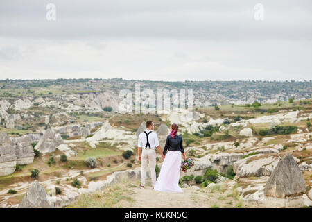 Valentine's day loving couple in nature hugs and kisses, man and woman love each other. Mountains of Cappadocia in Turkey beautiful couple celebrates  Stock Photo