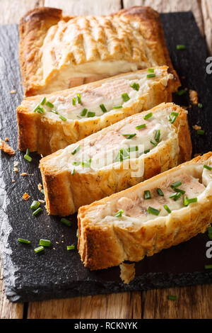 Traditional puff pastry pie stuffed with salmon with cheese close-up on the table. vertical Stock Photo