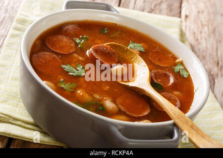 Polish traditional Breton beans with sausage close-up in a pan on the table. horizontal Stock Photo