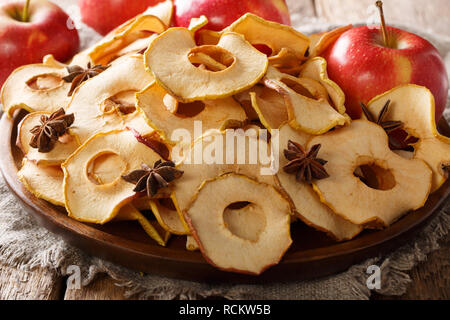 Apple chips with cinnamon and star anise close-up on a plate on the table. horizontal Stock Photo