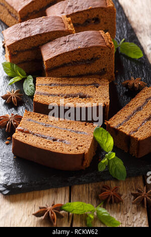 Old Polish ginger cake piernik with plum jam close-up on the table. vertical Stock Photo