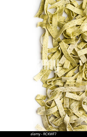 Raw italian pasta. Dry noodles with spinach isolated on white background. Stock Photo