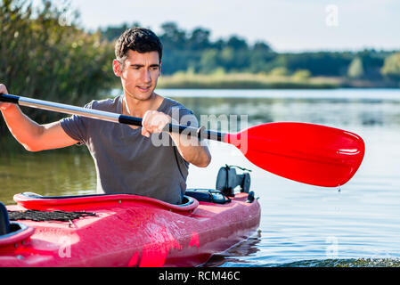Man kayaking on lake Stock Photo