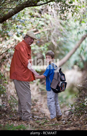 Grandfather and grandson holding hands while hiking Stock Photo