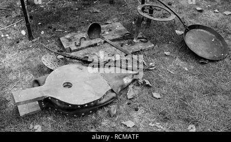Bellows, ladle, poker and frying pan - authentic campfire details at a Medieval Fair - monochrome processing Stock Photo