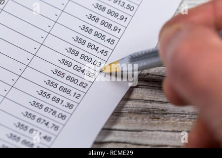 Close-up of a male hand with pen over on financial graphs and charts Stock Photo