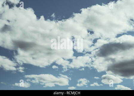 Looking up at a blue overcast summer sky with fluffy, soft white clouds - Concept of daydreaming, weather or meteorology Stock Photo
