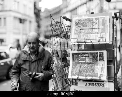 PARIS, FRANCE - OCT 28, 2017: Senior man next to french international newspaper with news from Spain about the Catalonia Referendum and protests in Barcelona - kiosk stand in city  Stock Photo