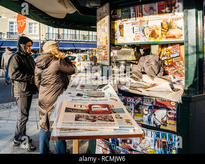 LISBON, PORTUGAL - FEB 10, 2018: Couple buying newspapers at the Lisbon Press kiosk at sunset  Stock Photo