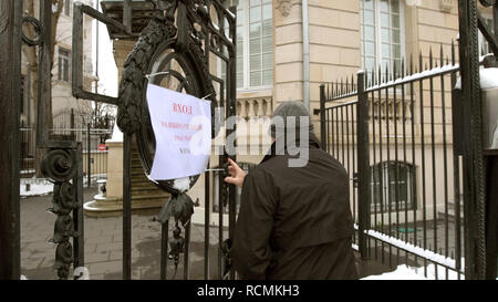 STRASBOURG, FRANCE - MAR 18, 2018: Pooling station text on paper at Russian presidential election 2018 with senior Russian male entering the gate of Consulate General of the Russian Federation to vote for President Stock Photo