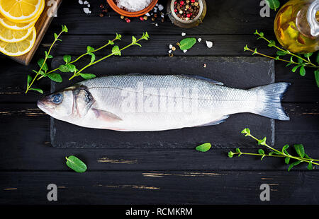 Raw fish. Sea bass on slate blackboard. Ingredients for cooking, grill, baked. Copy space. Top view Stock Photo