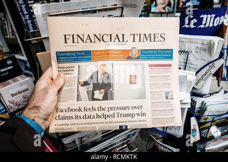 PARIS, FRANCE - MAR 19, 2017: Man reading buying British Financial Times newspaper at press kiosk featuring Russian presidential election from 2018 with the winner Vladimir Putin Stock Photo