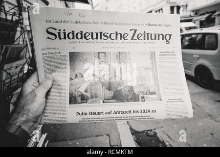 PARIS, FRANCE - MAR 19, 2017: Man reading buying German Sudeutsche Zeitung newspaper at press kiosk featuring Russian presidential election from 2018 and situation in the country with senior woman black and white,  Stock Photo