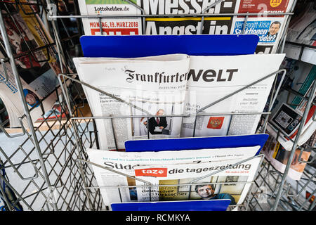 PARIS, FRANCE - MAR 19, 2017: Man reading buying newspaper at press kiosk featuring Russian presidential election from 2018 with the winner Vladimir Putin Stock Photo
