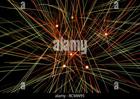 Closeup of fireworks exploding the in the sky, making abstract colorful lines through the darkness Stock Photo