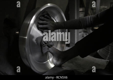 January 16, 2019 - Dhaka, Bangladesh - A worker polishing silver kitchen accessories at a workshop on hazard condition for low wages near Kamrangir Char. (Credit Image: © MD Mehedi Hasan/ZUMA Wire) Stock Photo