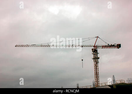 Construction crane bottom view in operation with cloud sky background. Tower crane on the background of the sky. Stock Photo