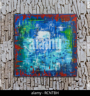 Abstract colorful oil painting on canvas painted by Attila Hajnal, hanging on stone wall Stock Photo