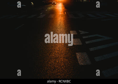 Urban background of a dark street at dusk with cars and traffic marks Stock Photo