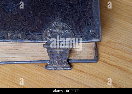 corner of old bible with metal clasp on wood Stock Photo
