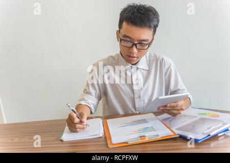 Businessman working on tablet and financial document Stock Photo