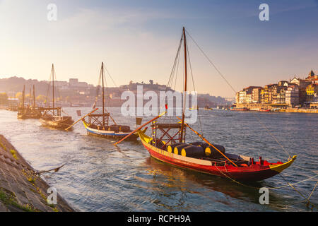 Port wine boats at the waterfront with the old town on the Douro River in Ribeira in the city centre of Porto in Porugal, Europe. Portugal, Porto Stock Photo