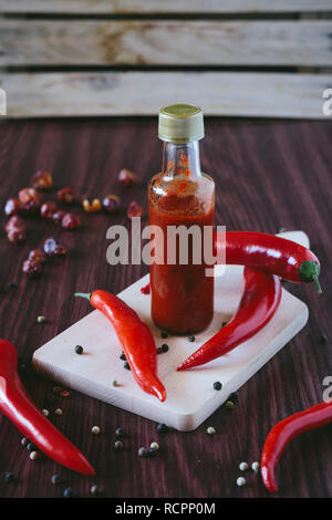 Homemade hot sauce in a bottle on a wooden background Stock Photo