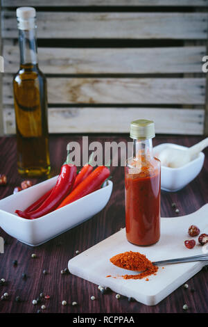 Homemade hot sauce in a bottle on a wooden background Stock Photo