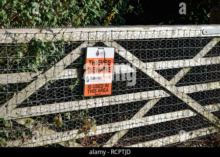 Sign on a five bar gate in the countryside warning 'Thieves Beware' forensic marking in use in the area, Surrey Hills England UK Stock Photo