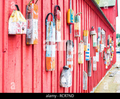 colorful fishing buoys hanging on the red wall of the famous fishing shack named Motif #1 in Rockport, Massachusetts Stock Photo