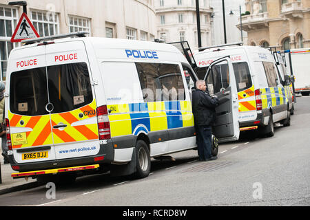 Metropolitan Police vans with officers on stand-by in Portland Place, London, to ensure public safety and security at a national protest demonstration. Stock Photo