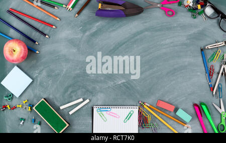 Back to school concept with erased green chalkboard and a variety of ...