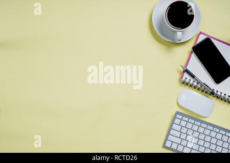 Office desk table with laptop,smart phone,cup of coffee,pen,pencil and notebook.Flat lay photo.Top view with copy space.Office supplies and gadgets on Stock Photo