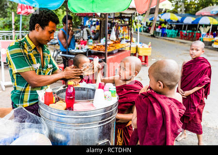 YANGON, MYANMAR - DECEMBER 16, 2016 : Buddhist monk children students buying ice cream Yangon (Rangoon) in Myanmar (Burma) Stock Photo