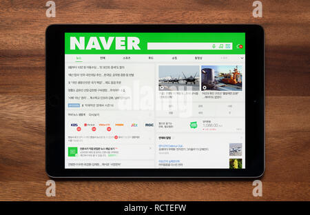 The website of Naver is seen on an iPad tablet, which is resting on a wooden table (Editorial use only). Stock Photo